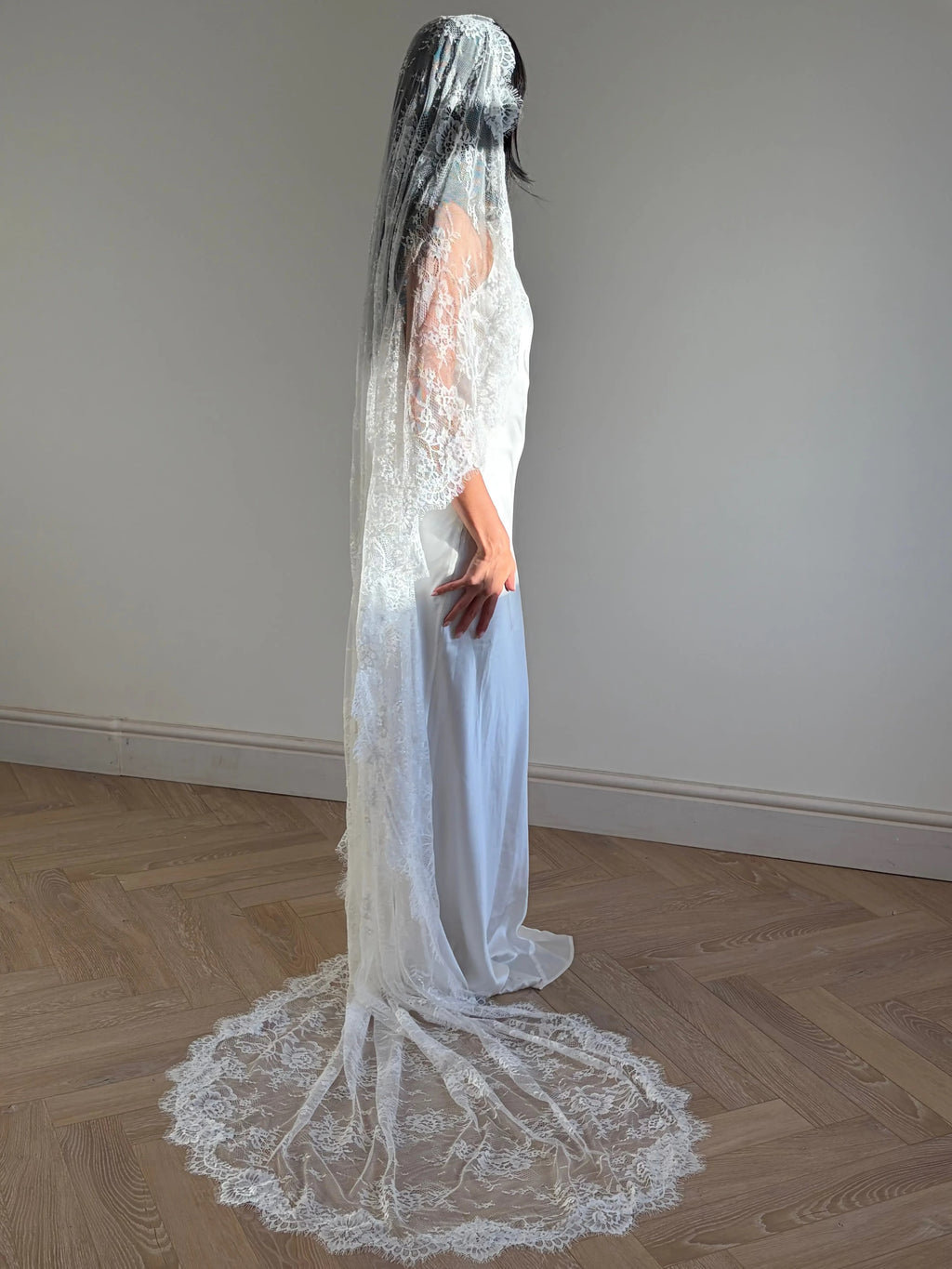 The Mantilla-Style Chantilly Rose Full Lace Veil is a cathedral-length bridal statement piece, designed for timeless elegance. Made from soft, lightweight tulle, it features intricate Chantilly rose lace that frames the veil completely, creating a delicate, romantic finish. The veil drapes beautifully straight to the ground, evoking a graceful, ethereal silhouette.This a vintage take on spanish style mantilla veil.