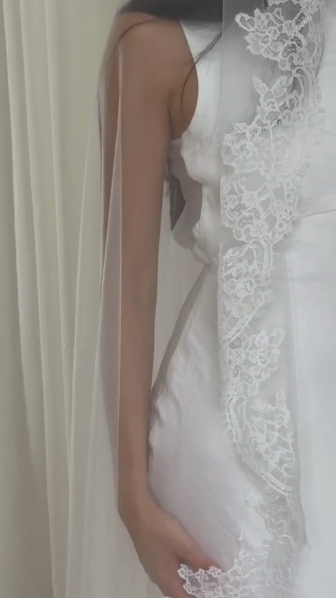 Soft off-white chapel bridal veil made from lightweight tulle with delicate lace trim along the edges for a dreamy, romantic look