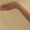 Close-up of a hand running through soft airy tulle from a Bryde wedding veil, showing its light and delicate texture.