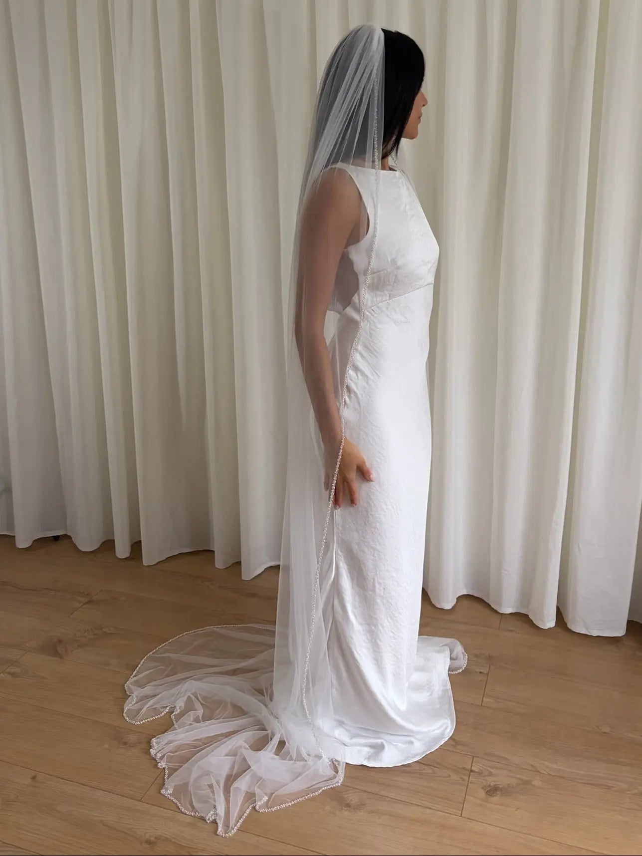 Soft tulle wedding veil with hand-placed pearl trim, perfect for modern and classic brides seeking an elegant bridal accessory
