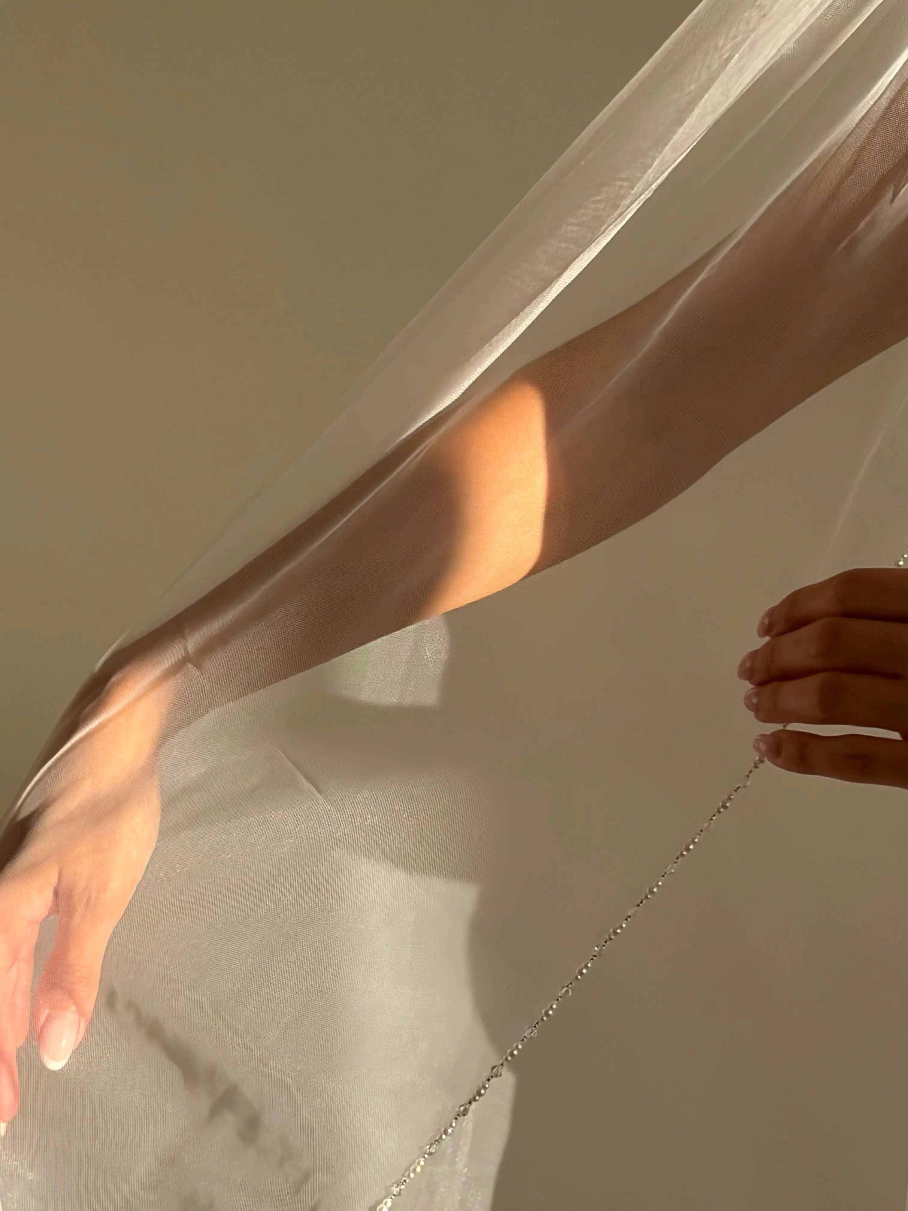 The Cathedral-Length Pearl Trim Veil features soft tulle and pearls & beads for a timeless, romantic bridal look. Lightweight and ethereal, it drapes beautifully for a graceful, luminous finish — perfect for modern or classic brides. The cloak-like full length veil finish is perfcet for the ethreal look.