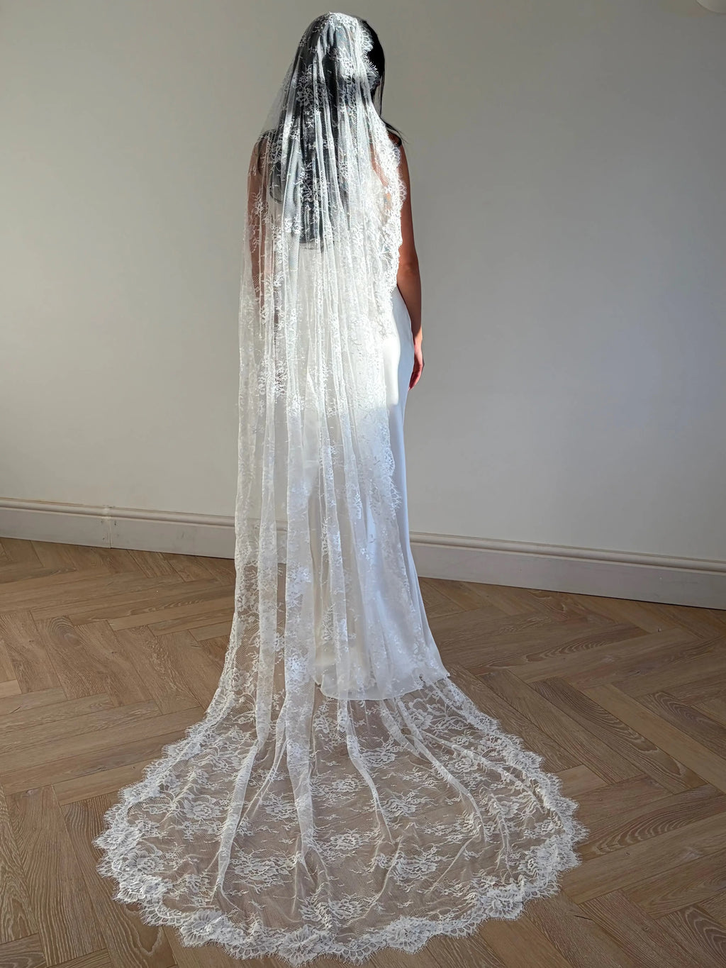 The Mantilla-Style Chantilly Rose Full Lace Veil is a cathedral-length bridal statement piece, designed for timeless elegance. Made from soft, lightweight tulle, it features intricate Chantilly rose lace that frames the veil completely, creating a delicate, romantic finish. The veil drapes beautifully straight to the ground, evoking a graceful, ethereal silhouette.This a vintage take on spanish style mantilla veil.