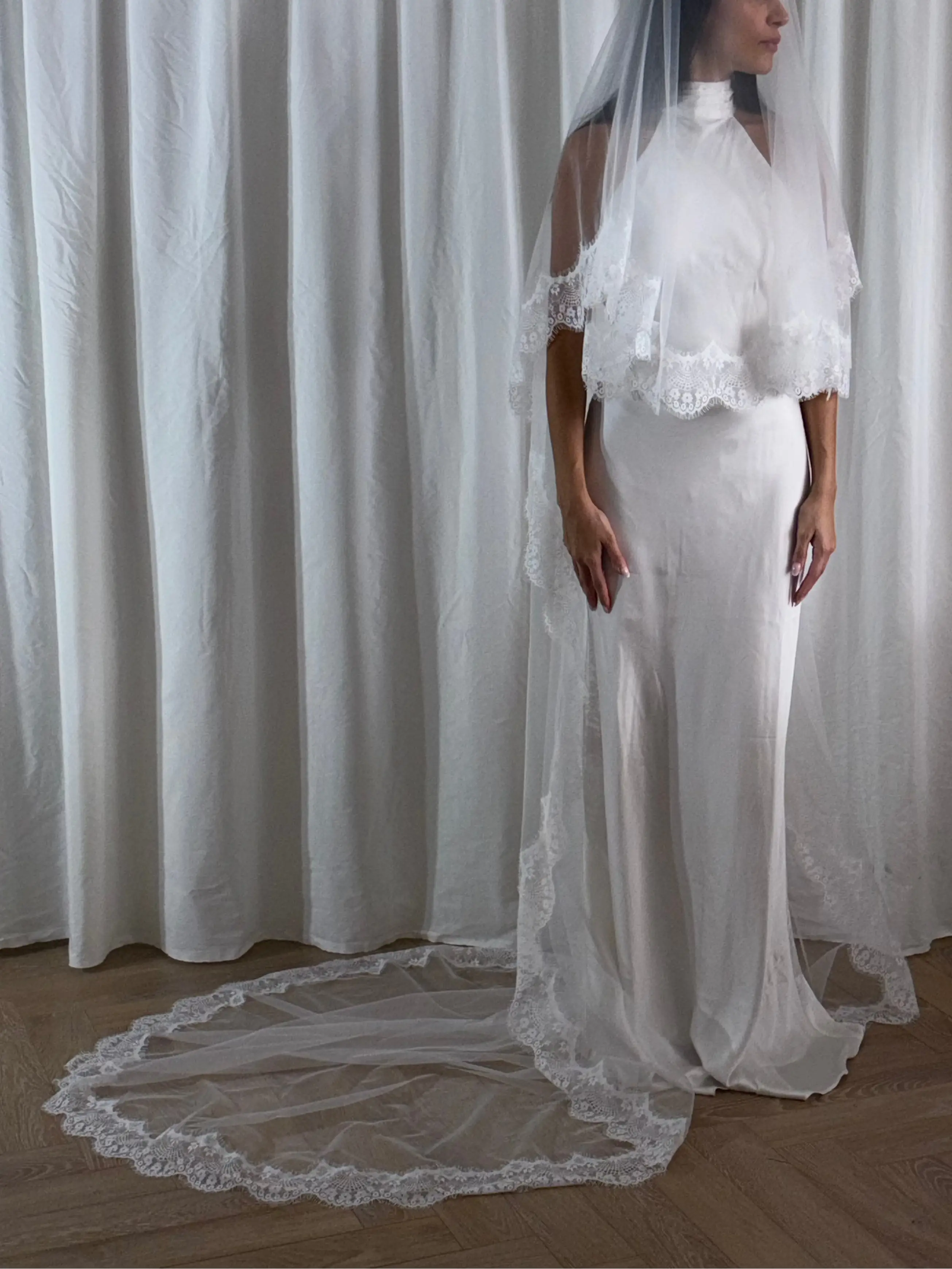 The Eyelash Trim Blusher Veil is a light, romantic accessory for modern brides seeking an ethereal finishing touch. Made from soft, flowing tulle, it features delicate eyelash lace along the edge for a subtle, feminine detail. The veil drapes softly over the face and shoulders, enhancing the bride’s silhouette with an airy, graceful effect. Its discreet comb attachment ensures a secure, seamless fit, making it ideal for both ceremony and photography. Perfect for adding a classic yet dreamy accent to any gow