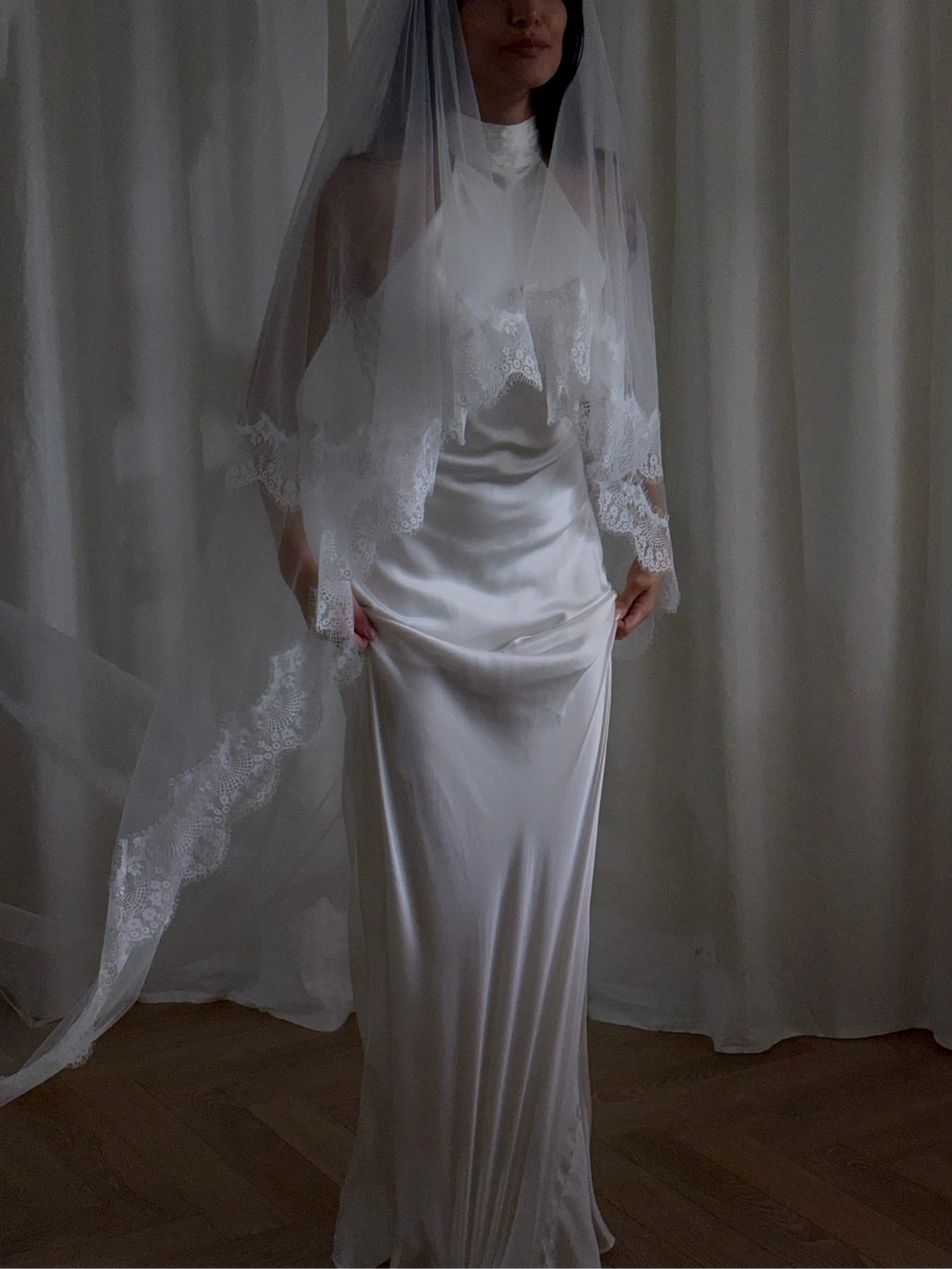 The Eyelash Trim Blusher Veil is a light, romantic accessory for modern brides seeking an ethereal finishing touch. Made from soft, flowing tulle, it features delicate eyelash lace along the edge for a subtle, feminine detail. The veil drapes softly over the face and shoulders, enhancing the bride’s silhouette with an airy, graceful effect. Its discreet comb attachment ensures a secure, seamless fit, making it ideal for both ceremony and photography. Perfect for adding a classic yet dreamy accent to any gow